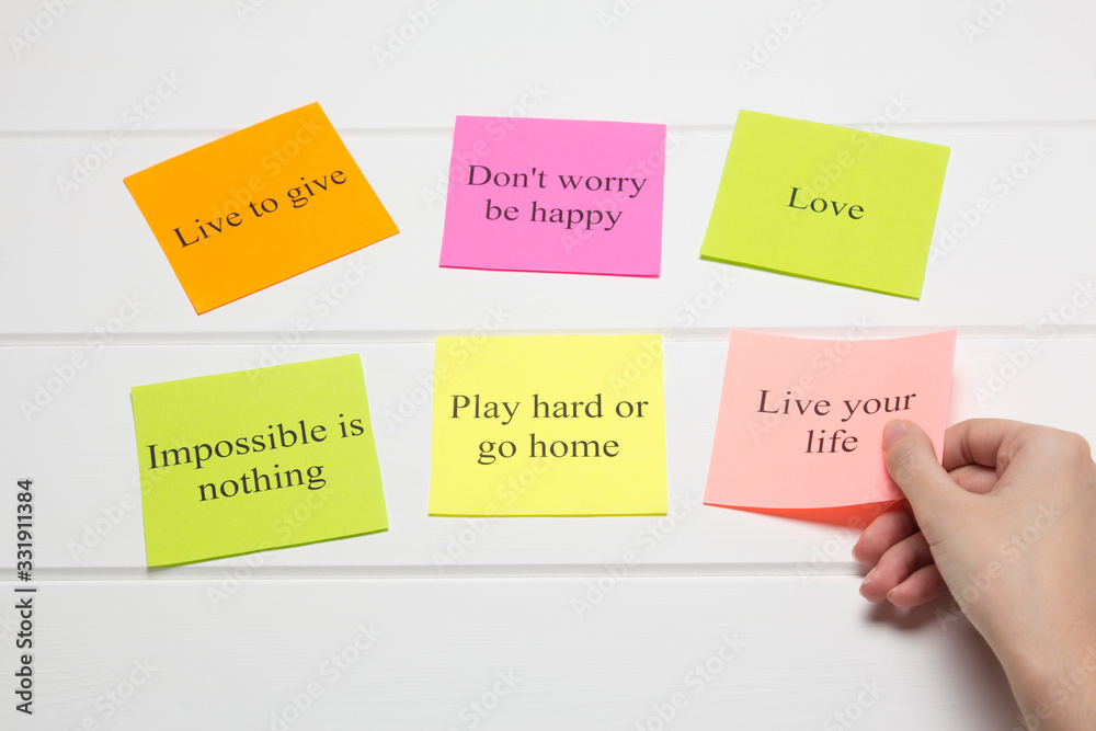 The hand lays out motivational cards. Color sheets with quotes. Visualization Board, self-discipline, development, training. Flat lay, top view. plan, strategy, concept, future. The hand lays out motivational cards. Color sheets with quotes. Visualization Board, self-discipline, development, training. Flat lay, top view. plan, strategy, concept, future.