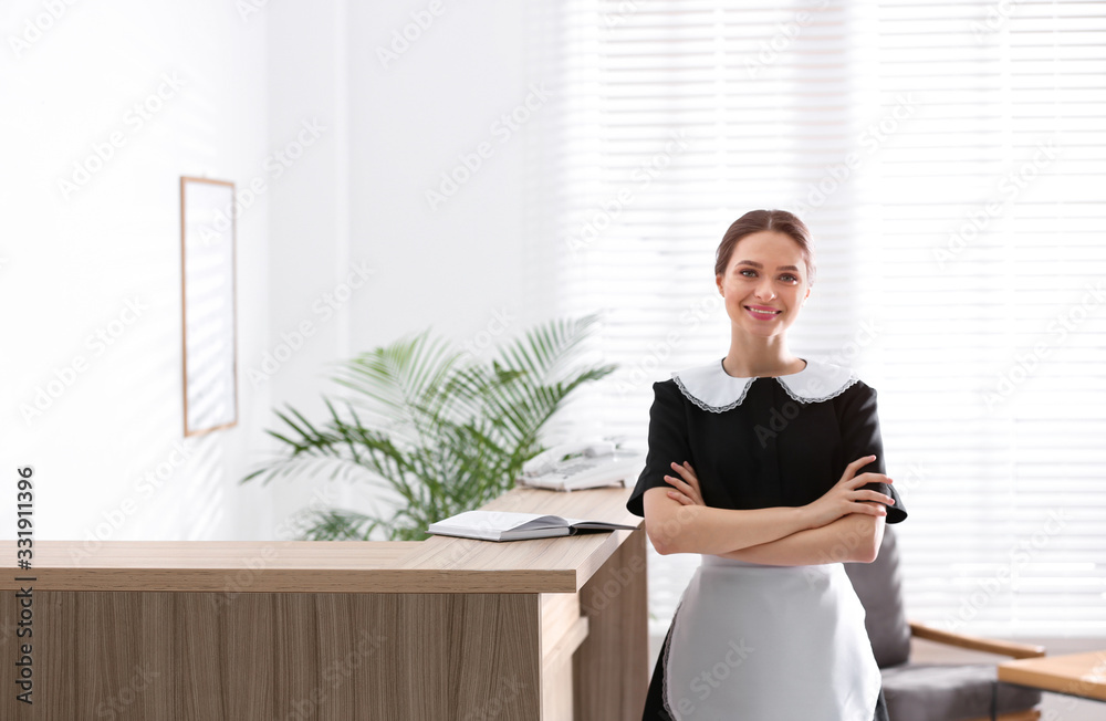 Young chambermaid near reception in hotel. Space for text Young chambermaid near reception in hotel. Space for text