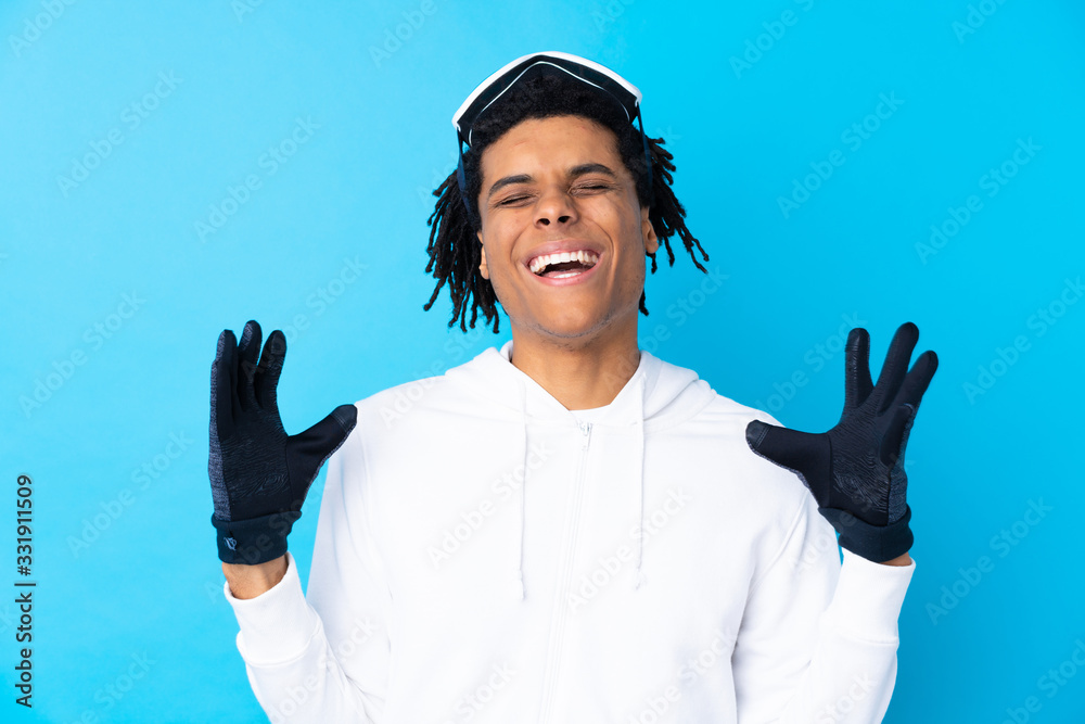 Naklejka premium Young African American man with snowboarding glasses laughing