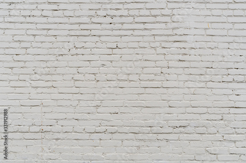 Fragment of a white painted brickwork of a wall of an old building under natural light. Close-up. Texture. Background.