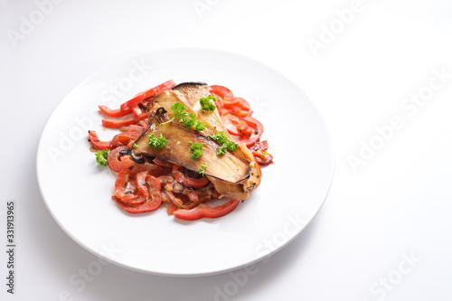King oyster mushrooms and red bell pepper on a white plate, healthy vegetable meal for low carb diet and vegetarians, white background with copy space, selected focus, narrow depth of field