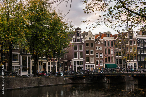 Cityscape of Amsterdam. Dutch city architecture. Modern exterior of buildings. Bridge over canal. Tourism in Europe.