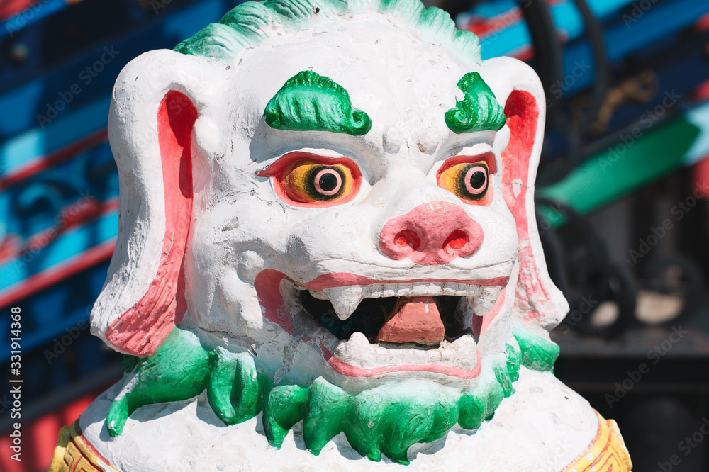 Stone statue of shishi lion covered with bright colors