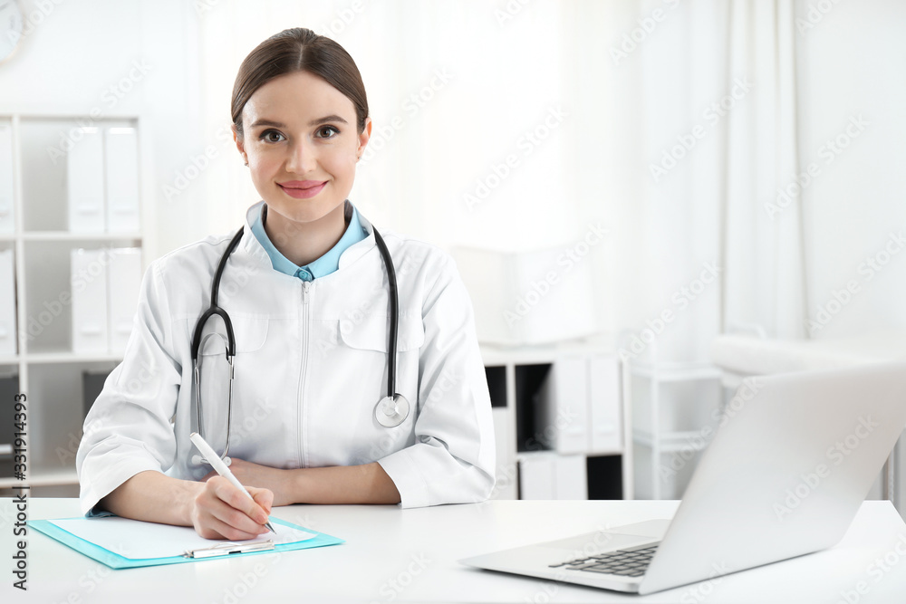 Portrait of young female doctor in white coat at workplace Portrait of young female doctor in white coat at workplace