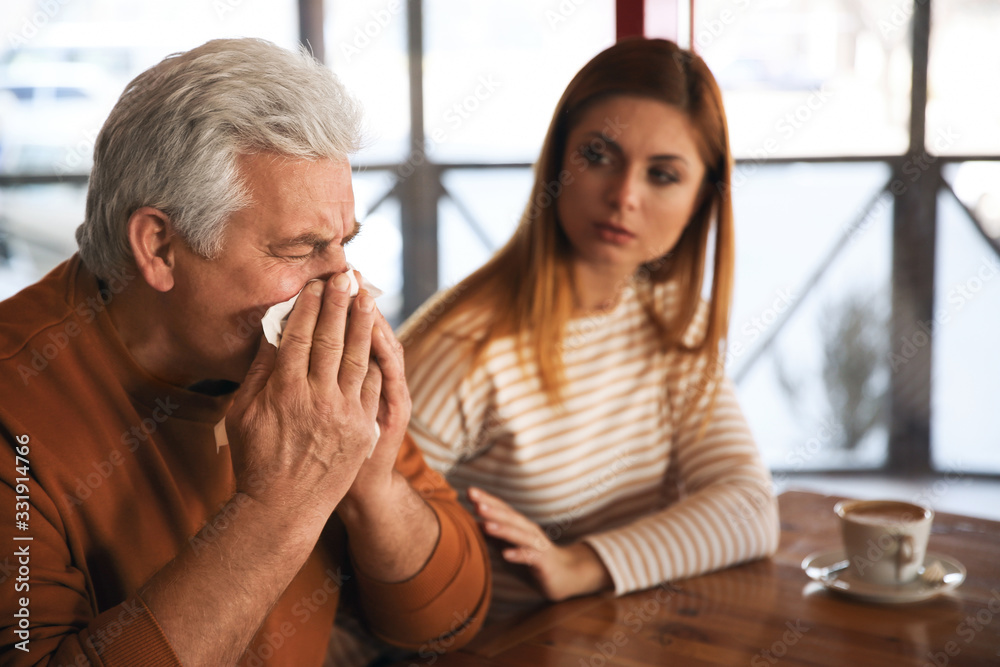 Sick senior man with tissue in cafe. Influenza virus Sick senior man with tissue in cafe. Influenza virus