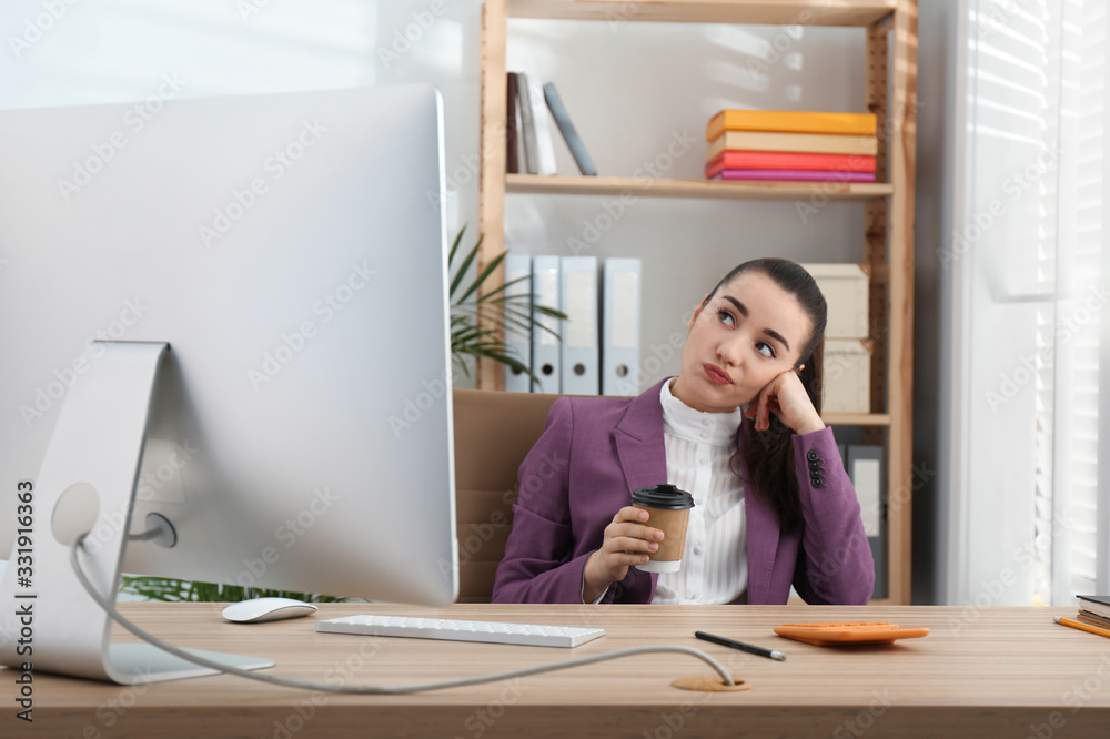 Lazy employee drinking coffee at table in office Lazy employee drinking coffee at table in office