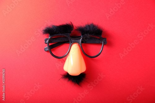 Overhead glasses, nose and mustache for April 1, April Fool's Day, on red background photo