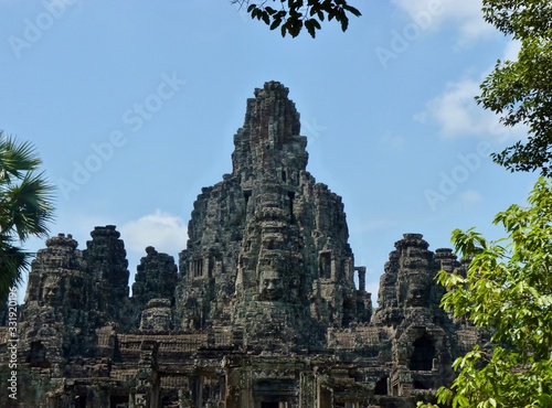 Ruins of Angkor, temple of Bayon with face towers, with trees, Angkor Wat, Cambodia