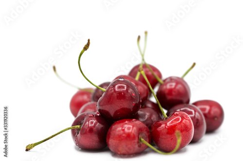 Ripe fresh organic cherries in dew drops isolated on white background.