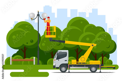 Yellow Engine Powered Scissor Lift. Worker with the help of an automobile tower change repairing a street pole.