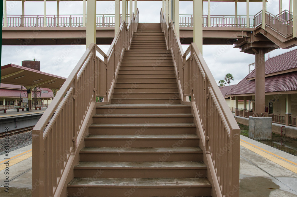 High stairs to bridge for railway crossing at train station High stairs to bridge for railway crossing at train station