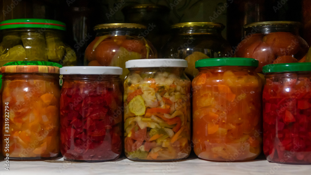 Pantry shelf with provisions in glass jars with pickled vegetables Pantry shelf with provisions in glass jars with pickled vegetables
