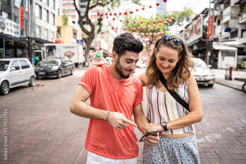 Couple looking at their mobile in the street