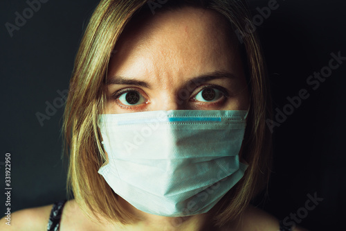 Girl in a medical mask with infected eyes