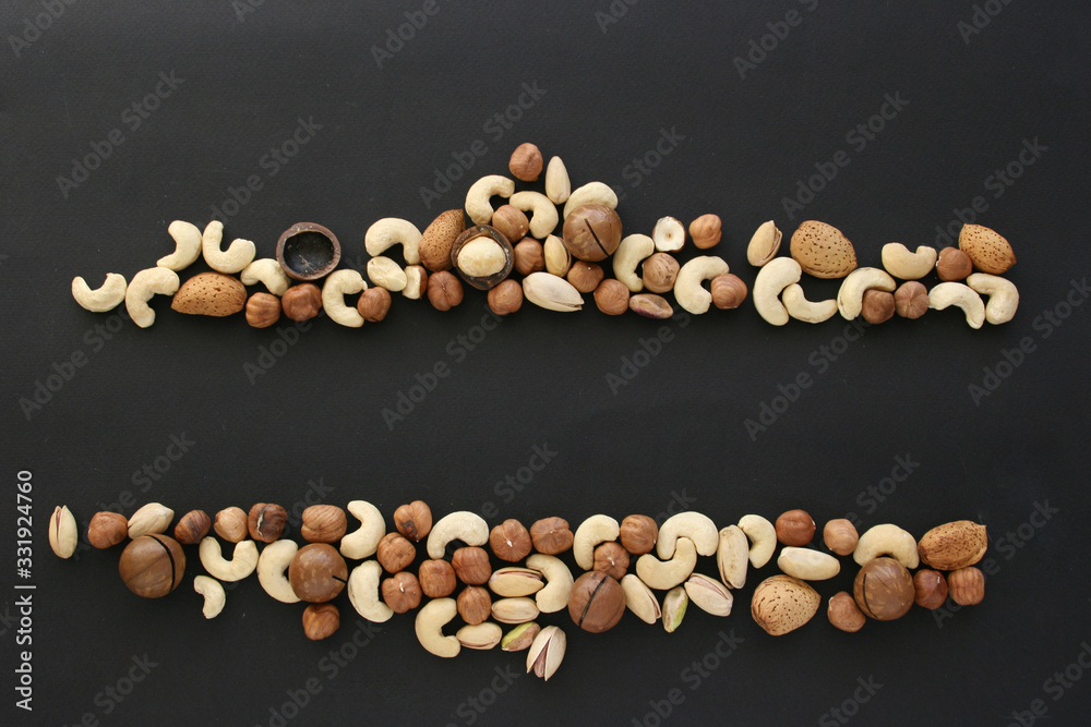 Nuts on black background, top view with copyspace. Assorted mixed nuts  isolated on dark table.