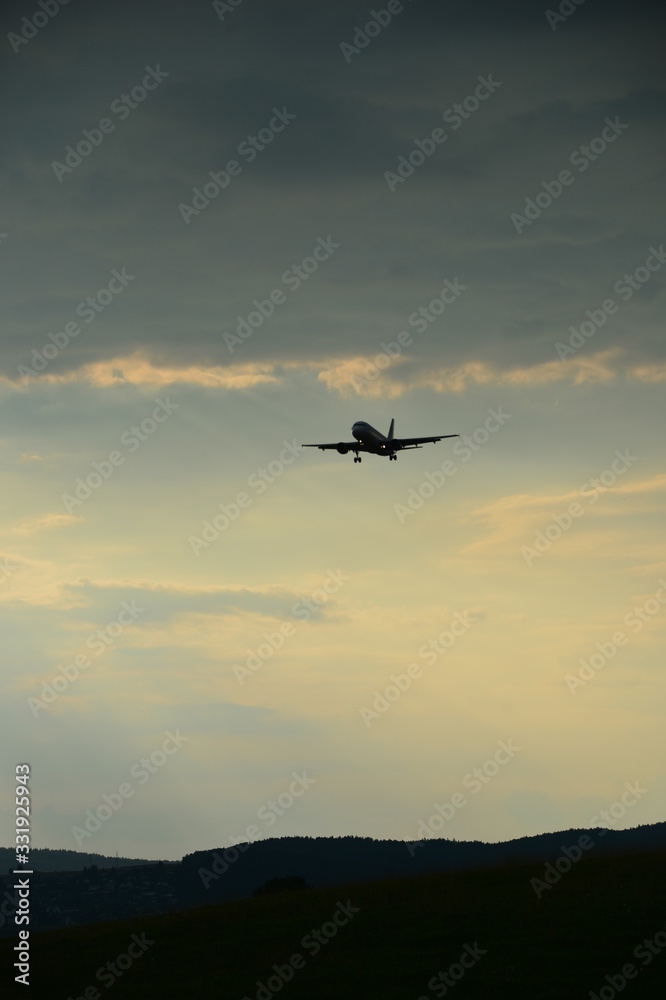 Silhouette of a landing plane in the evening sky