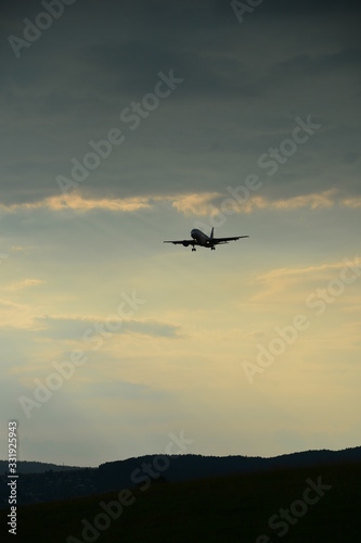 Silhouette of a landing plane in the evening sky
