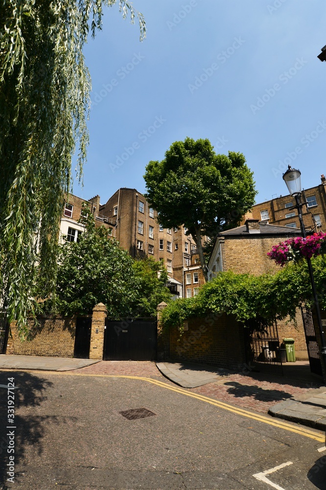 Beautiful old London houses with trees and blue sky