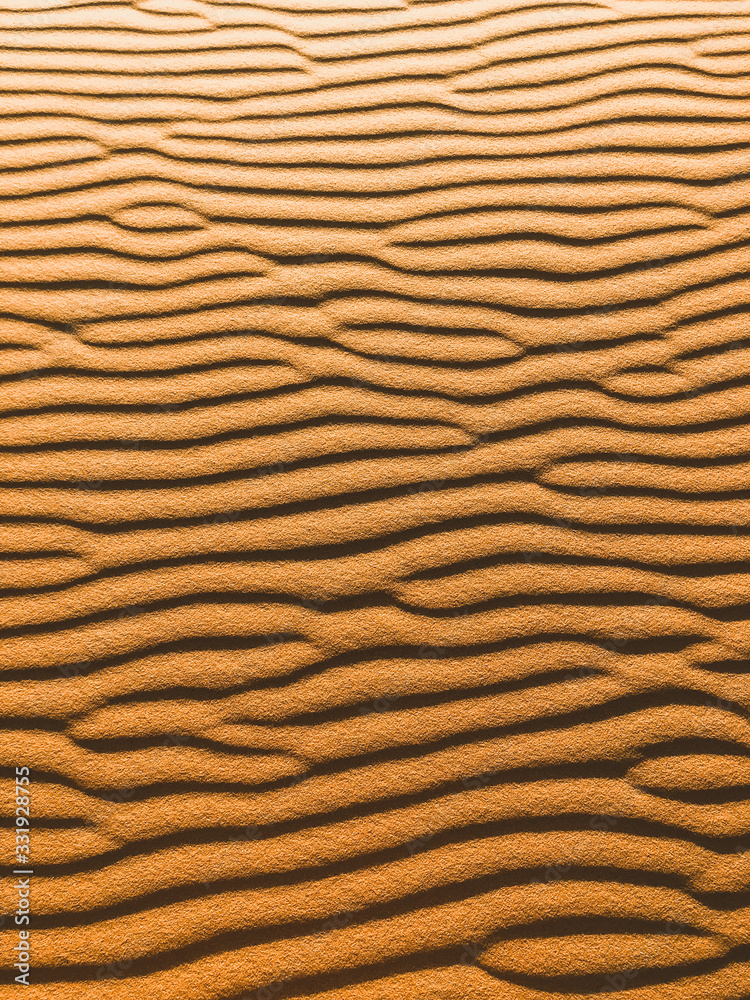 Orange vertical texture of sand dune. Abstract shape, background, shadow and sun light. Sahara desert. Orange vertical texture of sand dune. Abstract shape, background, shadow and sun light. Sahara desert.