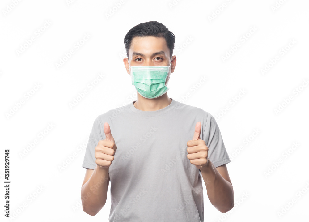 Young Asian Man wearing hygienic mask and showing thumbs up to prevent infection, 2019-nCoV or coronavirus. Airborne respiratory illness such as pm 2.5 fighting and flu isolated on white background. Young Asian Man wearing hygienic mask and showing thumbs up to prevent infection, 2019-nCoV or coronavirus. Airborne respiratory illness such as pm 2.5 fighting and flu isolated on white background.