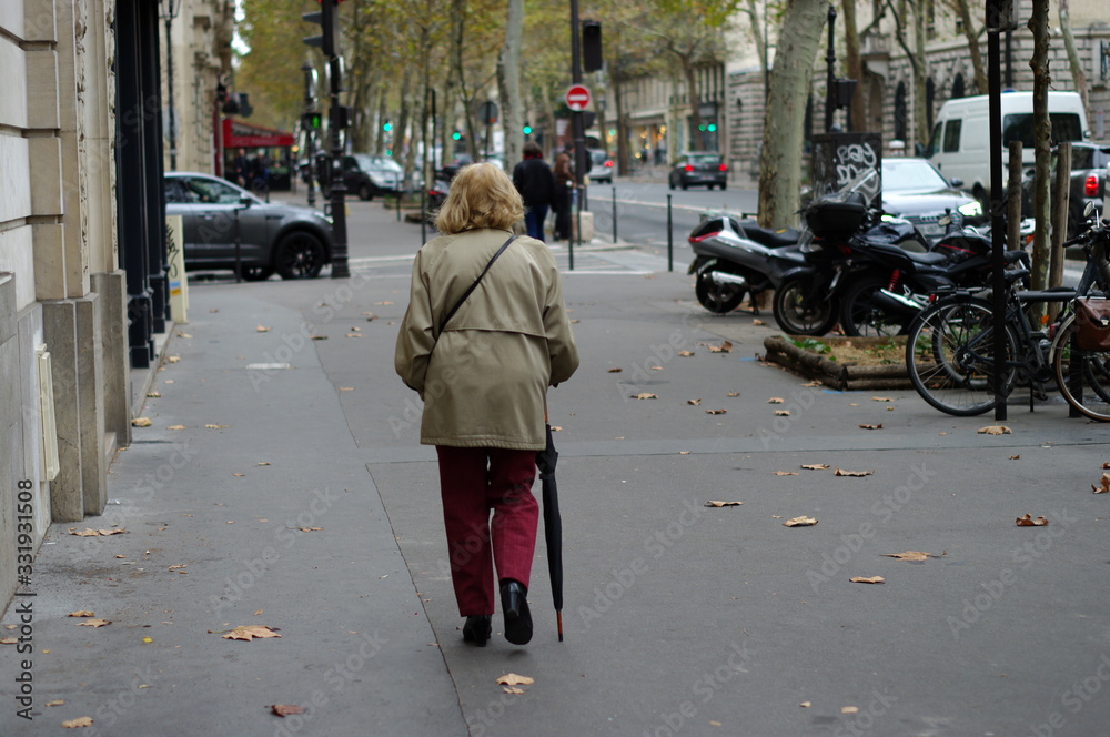 Vieille femme marchant en s'appuyant sur son parapluie, Paris