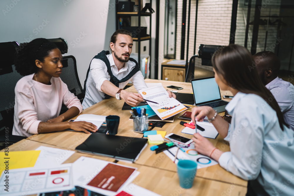 Multiethnic young office employees working on project together Multiethnic young office employees working on project together