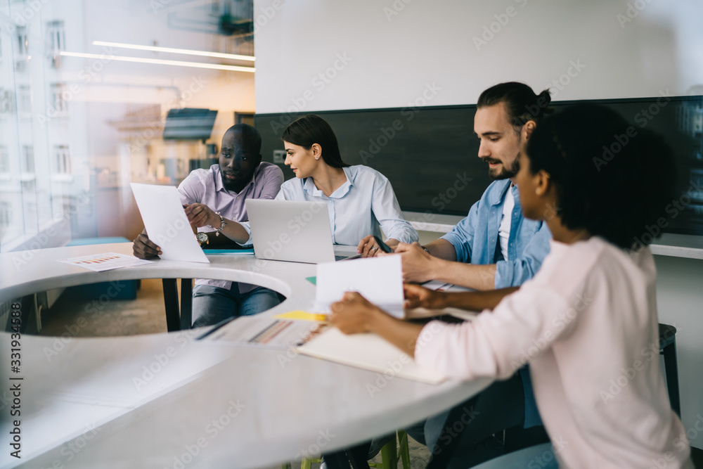 Work team checking papers at meeting in office Work team checking papers at meeting in office