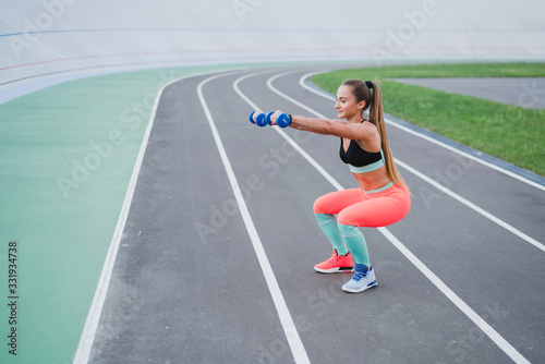 Sports and fitness outside the gym. Young fit woman with perfect body in sportswear trains outdoors on the playground. Sportive and healthy lifestyle, street work out, training, exercise concept.