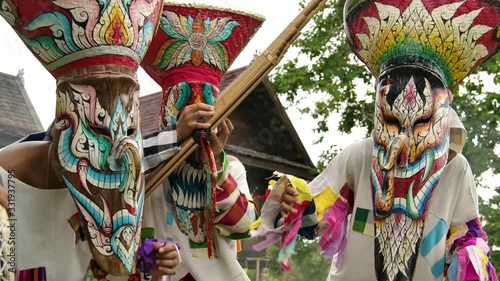 The  people in Thailand on phitakhon ghost festival holiday carnival wearing colorful custume clothes wearing hand paint mask dancing on street with happiness.  