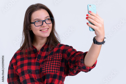 Portrait of young happy hipster woman taking selfie