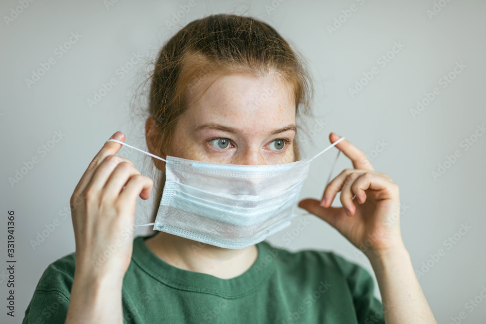 Woman puts on a protective medical mask. Prevention of infection and dissemination of coronavirus, quarantine