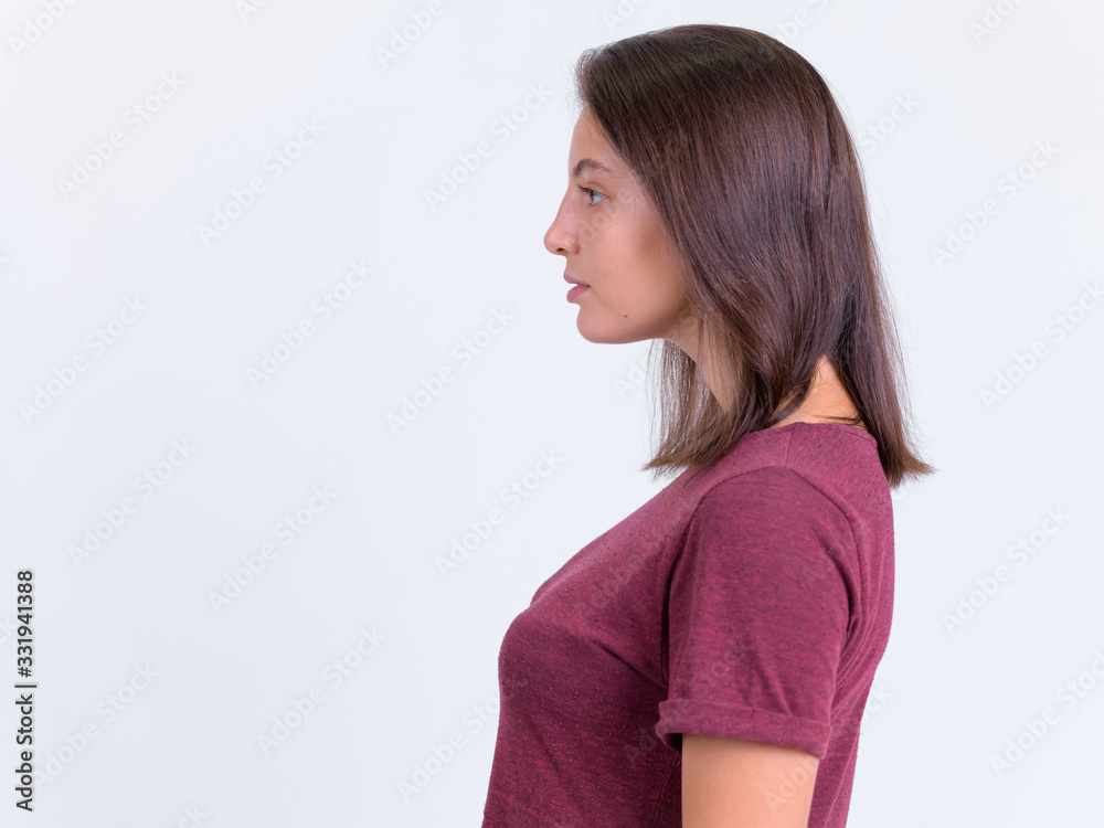 Profile view of young beautiful woman against white background Profile view of young beautiful woman against white background