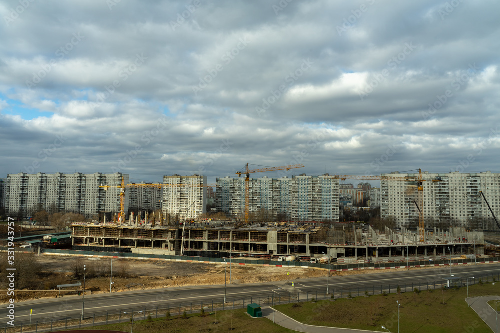 aerial view of a residential area of ​​the city with gray volumetric clouds and a construction site