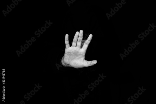 man's hand out of the dark. black and white