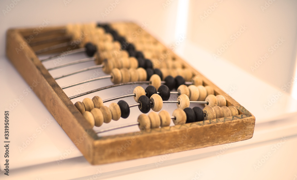 Old wooden scores. close-up abacus . Abacus on light and brown background. Concept of savings, counting. Accounting and Budget Concept Old wooden scores. close-up abacus . Abacus on light and brown background. Concept of savings, counting. Accounting and Budget Concept