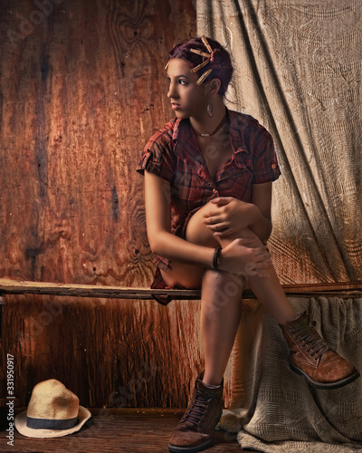 Joven campesina Santana con fondo de  madera con decoración de pelillos de tender  y en pose tranquila y sexy con camisa a cuadros carmelita photo