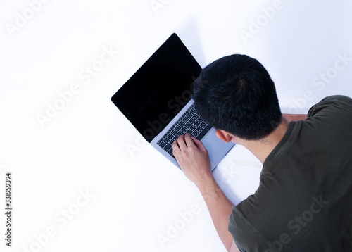 A Portrait of young asian wearing a green T-shirt take rest and using smartphone or laptop