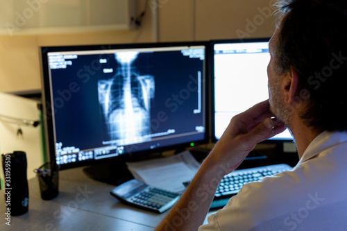 Interprétation radiographie pulmonaire coronavirus sur écran bureau par médecin radiologue photo