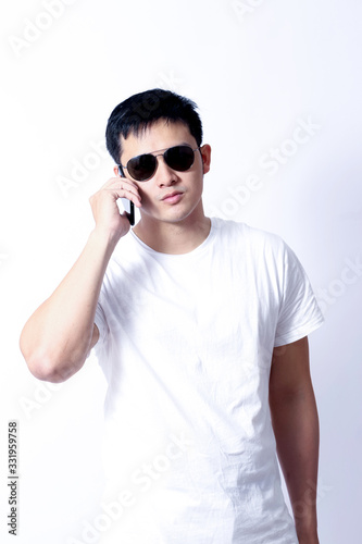 A Portrait of young asian wearing a Green t-shirt and white jeans showing gesture sign or devices