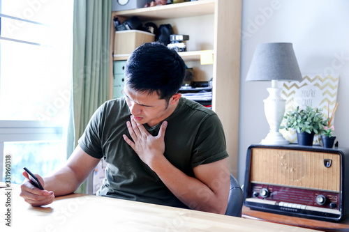 young asian wearing a green tshirt working with laptop in home office