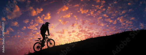 Canvas Print Cyclist riding uphill against majestic colorful sunset