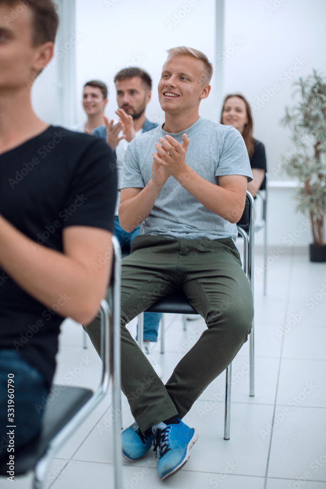 group of young people applaud at a group meeting group of young people applaud at a group meeting