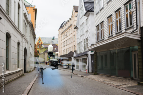 Drone spraying disinfectant on city street during coronavirus pandemic