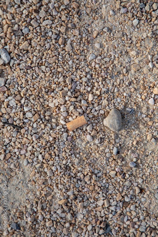 cigarette butt lies on gravel