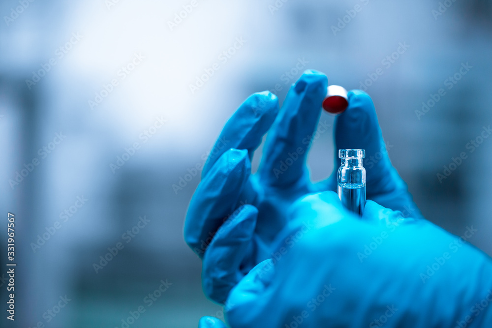 Close up of hand pharmacist with test tube with vaccine against virus, pharmacy concept Close up of hand pharmacist with test tube with vaccine against virus, pharmacy concept