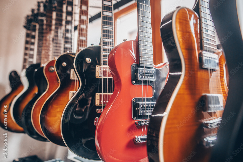 Naklejka premium Close up of professional electric guitar in a row in instrument shop, instrumental concept