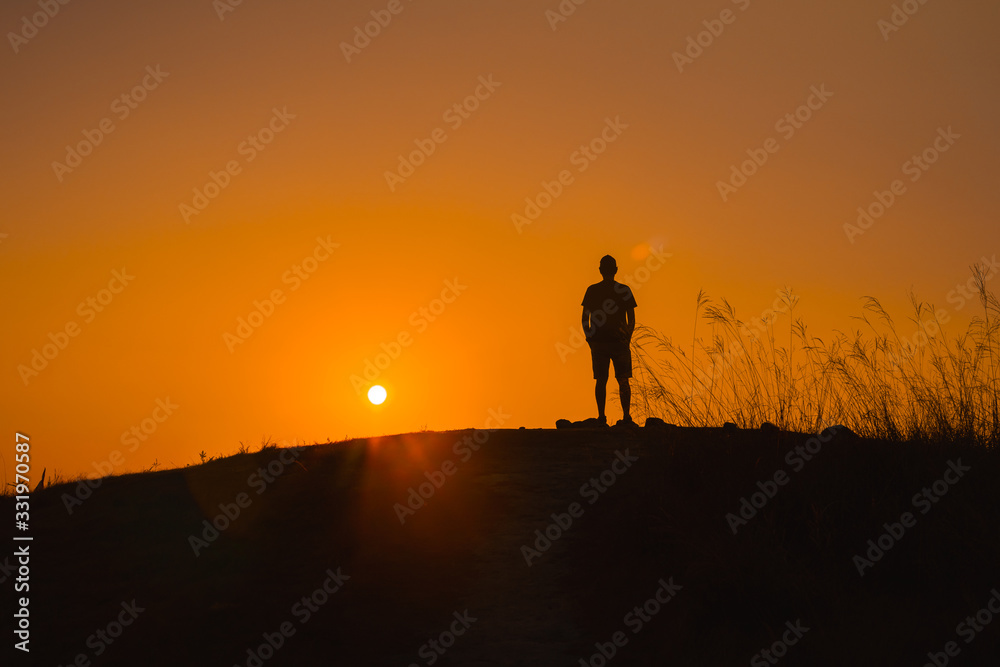 adventure travel from silhouette man hiking and stand on top of the mountain in summer season