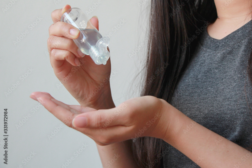 Naklejka premium Close up woman hands using wash hand sanitizer gel dispenser, against coronavirus or Covid-19 virus and other viruses.