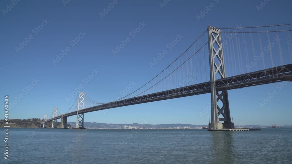 The San Francisco–Oakland Bay Bridge, locally as the Bay Bridge in the Sunny day at San Francisco Bay in California USA - Infrastructure The San Francisco–Oakland Bay Bridge, locally as the Bay Bridge in the Sunny day at San Francisco Bay in California USA - Infrastructure