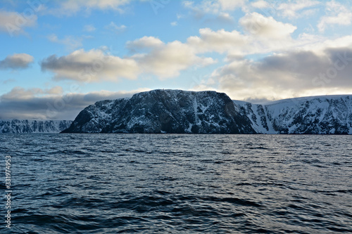 Nordkapp with snowy cliffs and blue water of Barents Sea